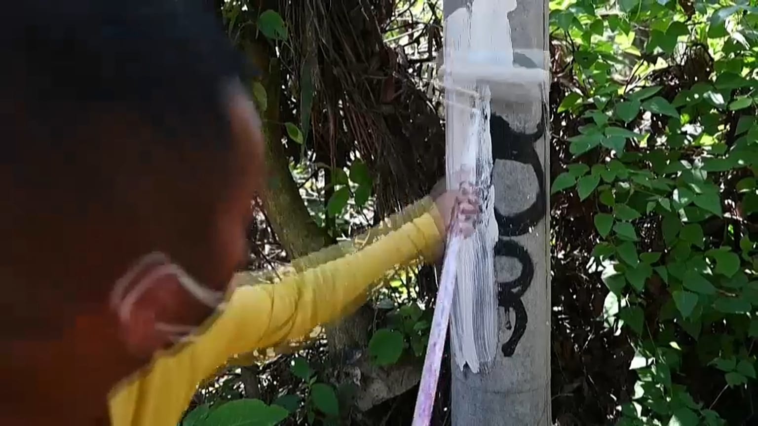 Un preso limpia una pintada de la mara Calle 18