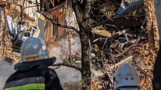 Firefighters work after a drone fired on buildings in Kyiv, 17 October 2022