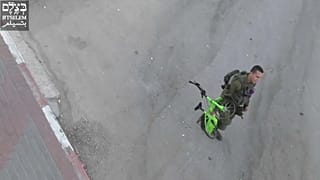 جندي إسرائيلي يصادر دراجة من طفل في الخليل.  