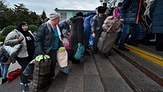 Departees from Kherson gather upon their arrival at the railway station in Dzhankoi, Crimea, 21 October 2022