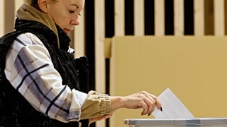 A woman casts her ballot for a presidential election at a poling station in Ljubljana, 23 October 2022