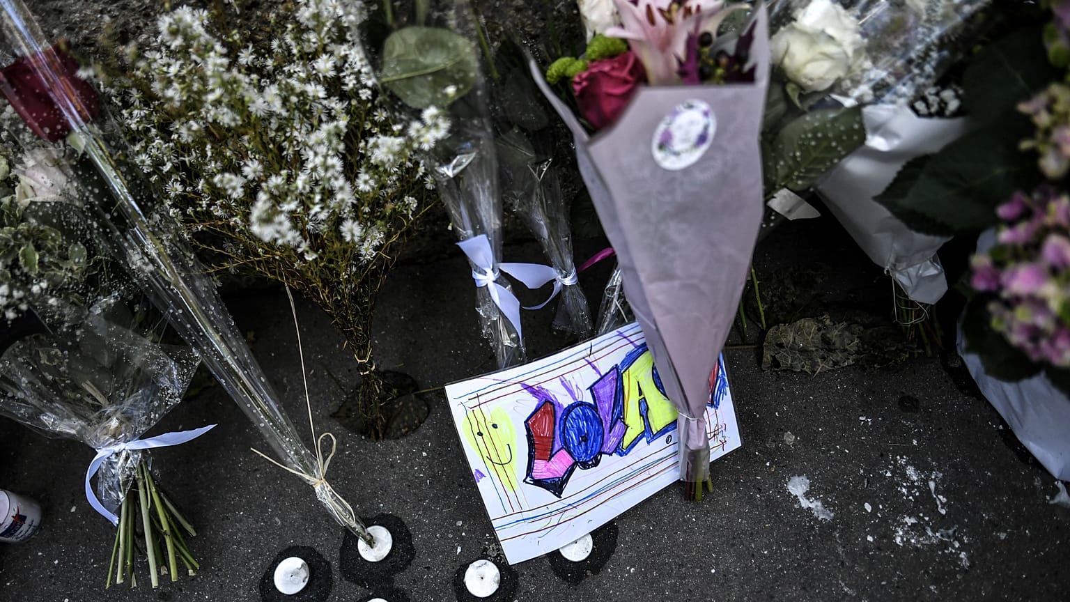 Bouquets et dessins disposés devant l'immeuble dans le 19ème arrondissement à Paris où habitait Lola, 12 ans, assassinée 