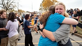 People embrace in the Schnucks Arsenal parking lot following a shooting at Central Visual Performing Arts High School in St. Louis on Monday, 24 October 2022.