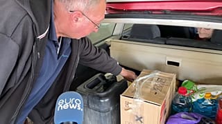 Egy román férfi azt mutatja a sireti határátkelőhelynél, hogy mit hozott Ukrajnából.