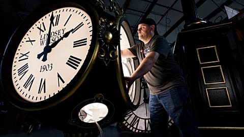 Dan LaMoore works on a Seth Thomas Post Clock at Electric Time Company, Friday, Oct. 23, 2020, in Medfield, Mass., US.