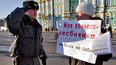Полицейский отдает честь перед проверкой документов у активиста движения за права геев на Дворцовой площади в Санкт-Петербурге, 20 ноября 2011 года