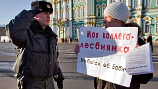 Полицейский отдает честь перед проверкой документов у активиста движения за права геев на Дворцовой площади в Санкт-Петербурге, 20 ноября 2011 года