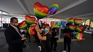 Trabajadores del registro civil mexicano decoran con globos en forma de corazón y con los colores del arco iris para una ceremonia de boda masiva entre personas del mismo sexo