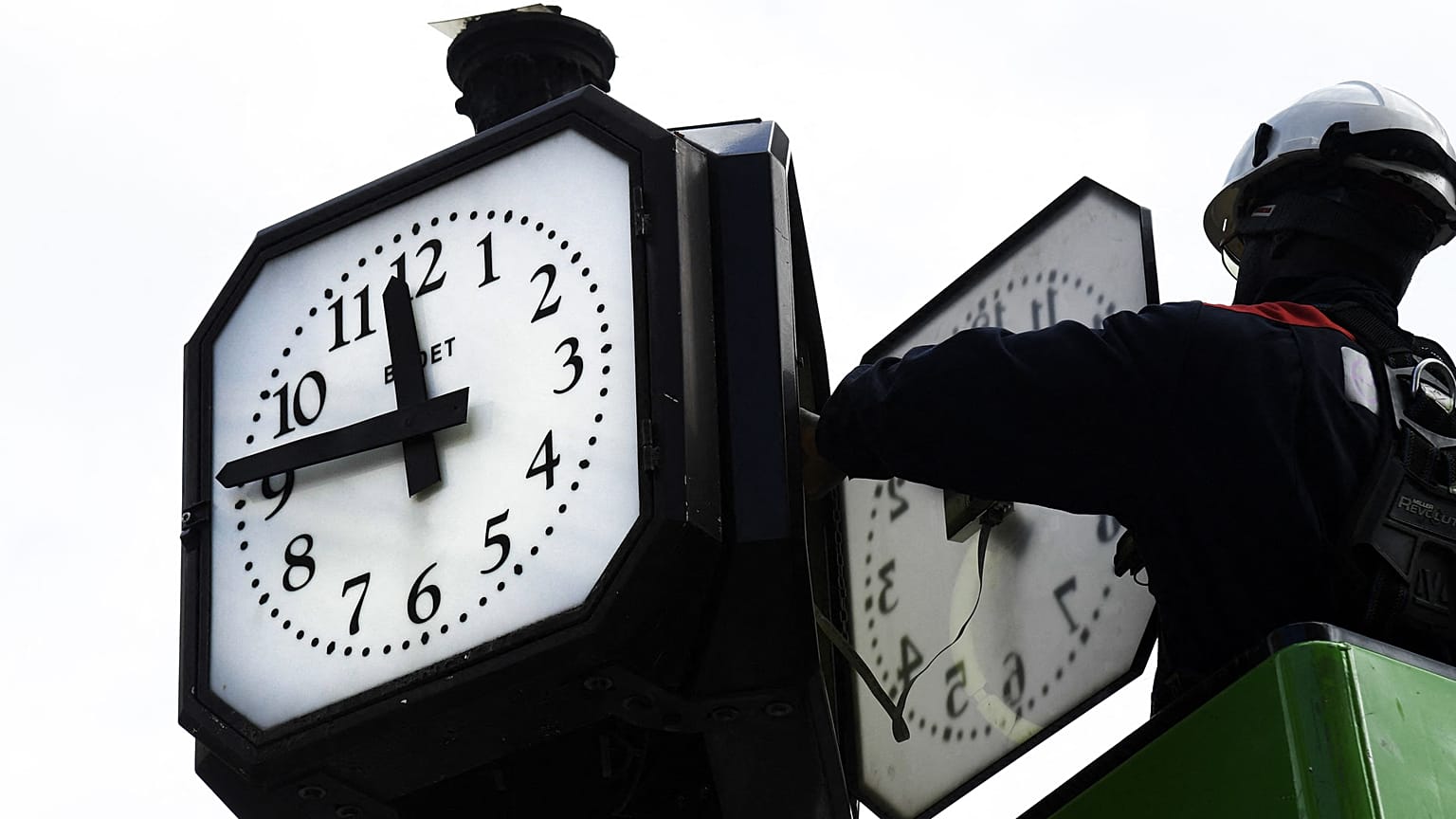Archives : ouvrier intervenant sur une horloge publique à Paris, le 26 mars 2021