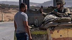 جندي من الجيش الإسرائيلي يصور فلسطينيا عند نقطة تفتيش بالقرب من مدينة نابلس بالضفة الغربية