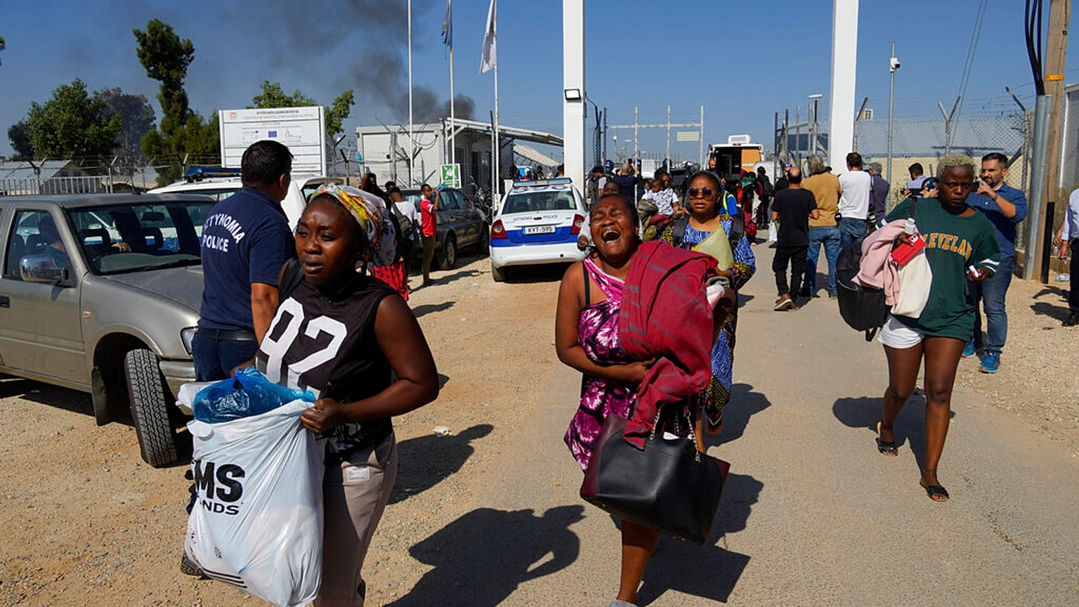 Female migrants exit the Pournara migrant reception center following fighting between rival groups inside the camp near the village of Kokkinotrimithia