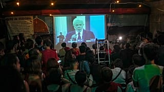 People watch at Bar Al Janiah as Brazil's former President Luiz Inacio Lula da Silva speaks during a televised presidential debate in Sao Paulo, Brazil, Friday, Oct. 28, 2022.