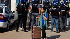 Μετανάστρια με την βαλίτσα της αποχωρεί από το κέντρο φιλοξενίας μεταναστών Πουρνάρα στην Κύπρο μετά τα επεισόδια στις εγκαταστάσεις