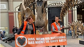 Activists from Germany's Uprising of the Last Generation hold a sign reading, "What if the government doesn't have it under control?"