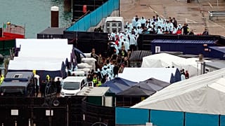 Un groupe de personnes au centre de traitement des migrants à Douvres, en Angleterre, dimanche 30 octobre 2022.