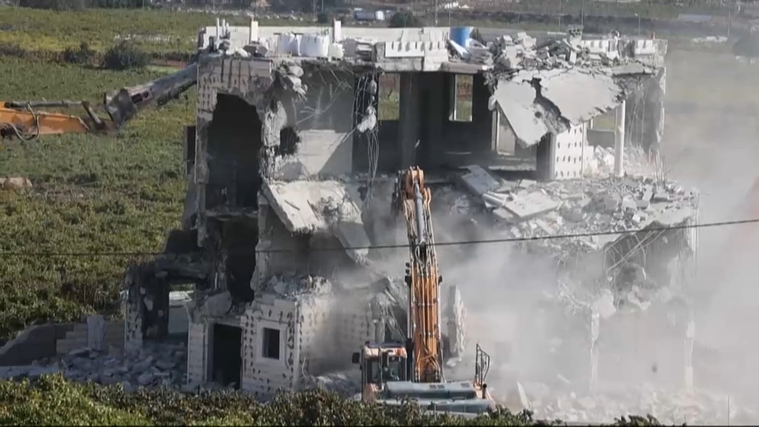 Israeli army bulldozers demolishing a building in Hebron