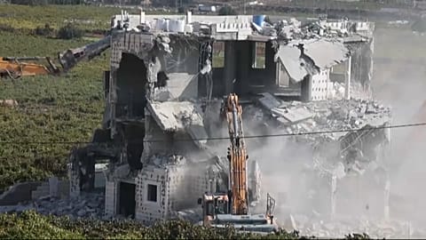 Israeli army bulldozers demolishing a building in Hebron