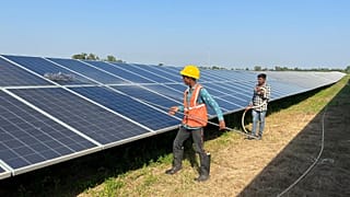 Workers clean panels at a solar park in Modhera.