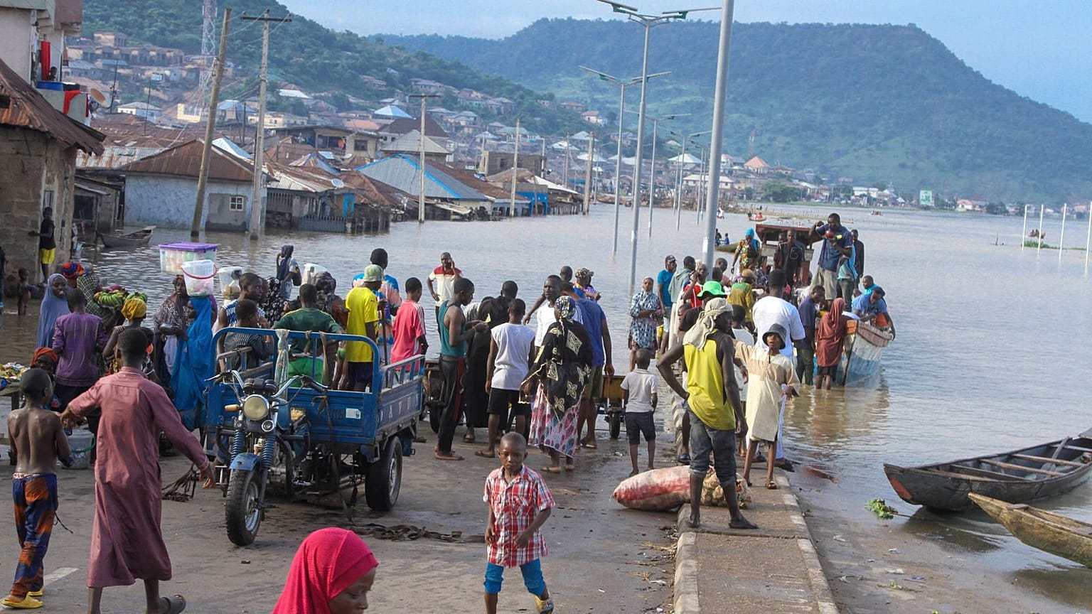 People were stranded due to floods following several days of downpours In Kogi, Nigeria, last month. THe Nigerian state gas company declared a force majeure.