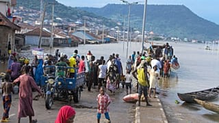 People were stranded due to floods following several days of downpours In Kogi, Nigeria, last month. THe Nigerian state gas company declared a force majeure.