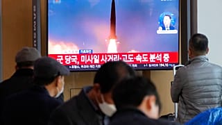 Dél-koreai emberek nézik a híradót a repülőtéren