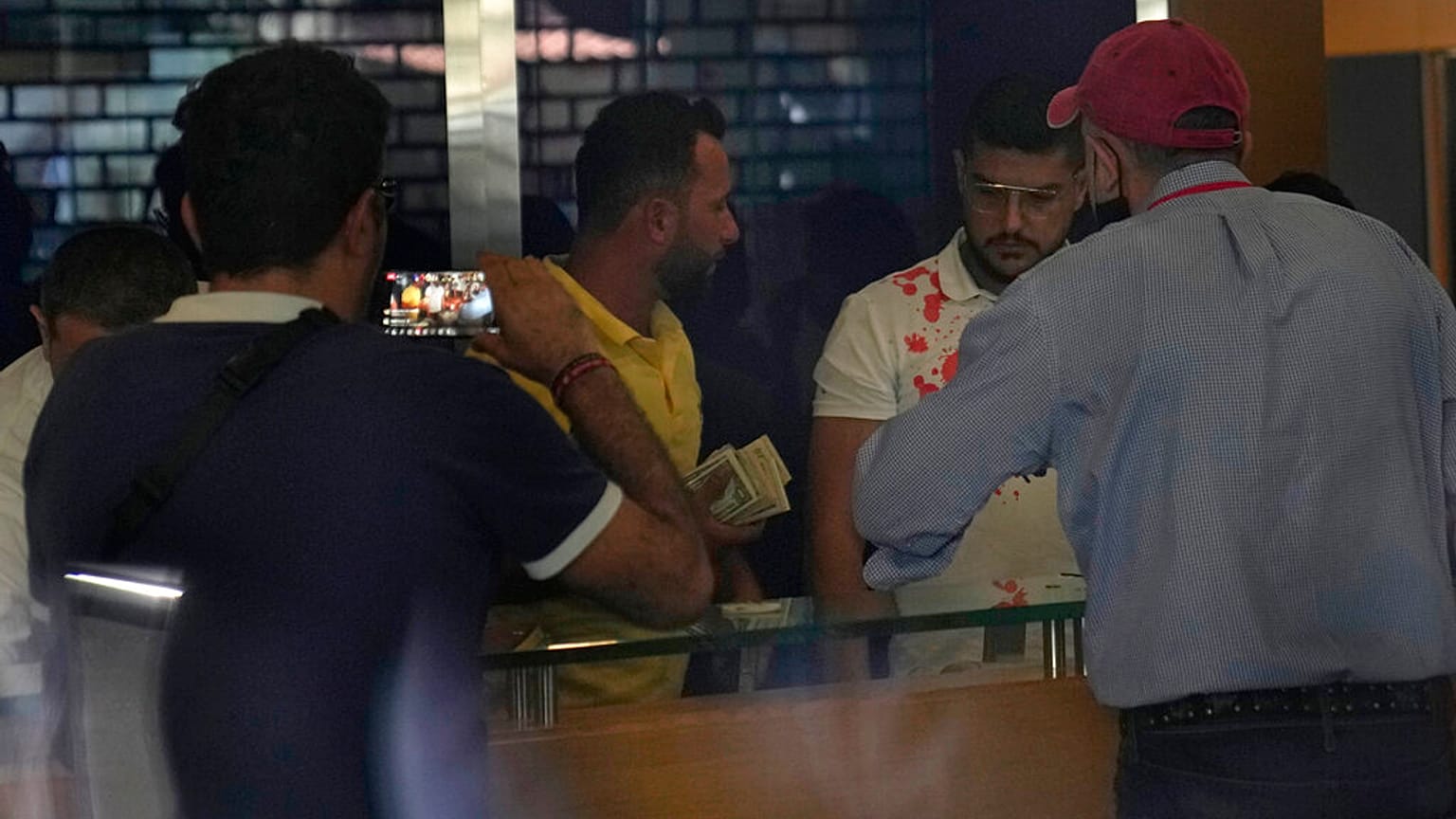 يتلقى المودع الذي هاجم بنكًا مع امرأة مسلحة و12 ناشطا دولارات أمريكية في بيروت، لبنان، الأربعاء 14 سبتمبر 2022.