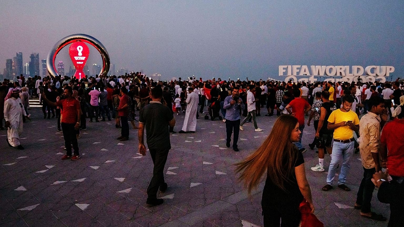 People take photographs in front of the official FIFA World Cup Countdown Clock on Doha's corniche, in Qatar.