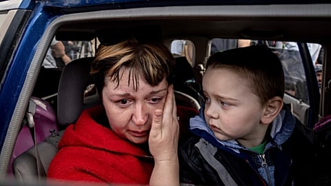 Natalia Pototska, 43, cries as her grandson Matviy looks on in a car at a center for displaced people in Zaporizhzhia, Ukraine.