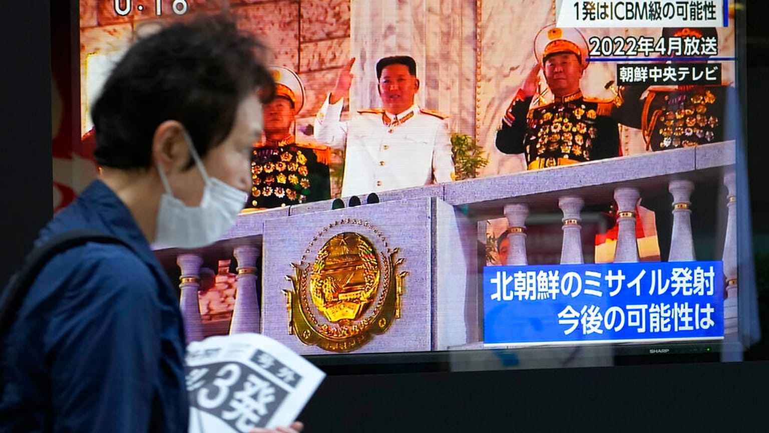 Japonya'nın başkenti Tokyo'da, Kuzey Kore'nin fırlattığı füzelerle ilgili haberleri gösteren TV ekranların önünden geçerken