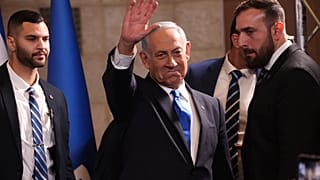 نتنياهو ملوحاً بيده لأنصاره داخل مركز حزب الليكود بعدما أشارت الاستطلاعات إلى تقدمه في الانتخابات 