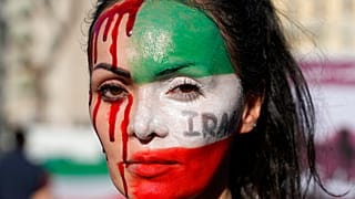 Mujer con el rostro cubierto por la bandera de Irán