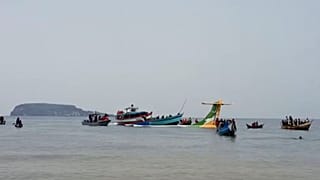 Rescuers in boats are seen around the tail fin of a crashed Precision Air passenger aircraft on the shores of Lake Victoria in Bukoba, 6 November 2022