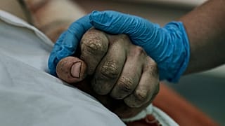 A medic holds hand of a Ukrainian soldier wounded in a battle with the Russian troops in a city hospital in Mykolayiv, 3 November 2022