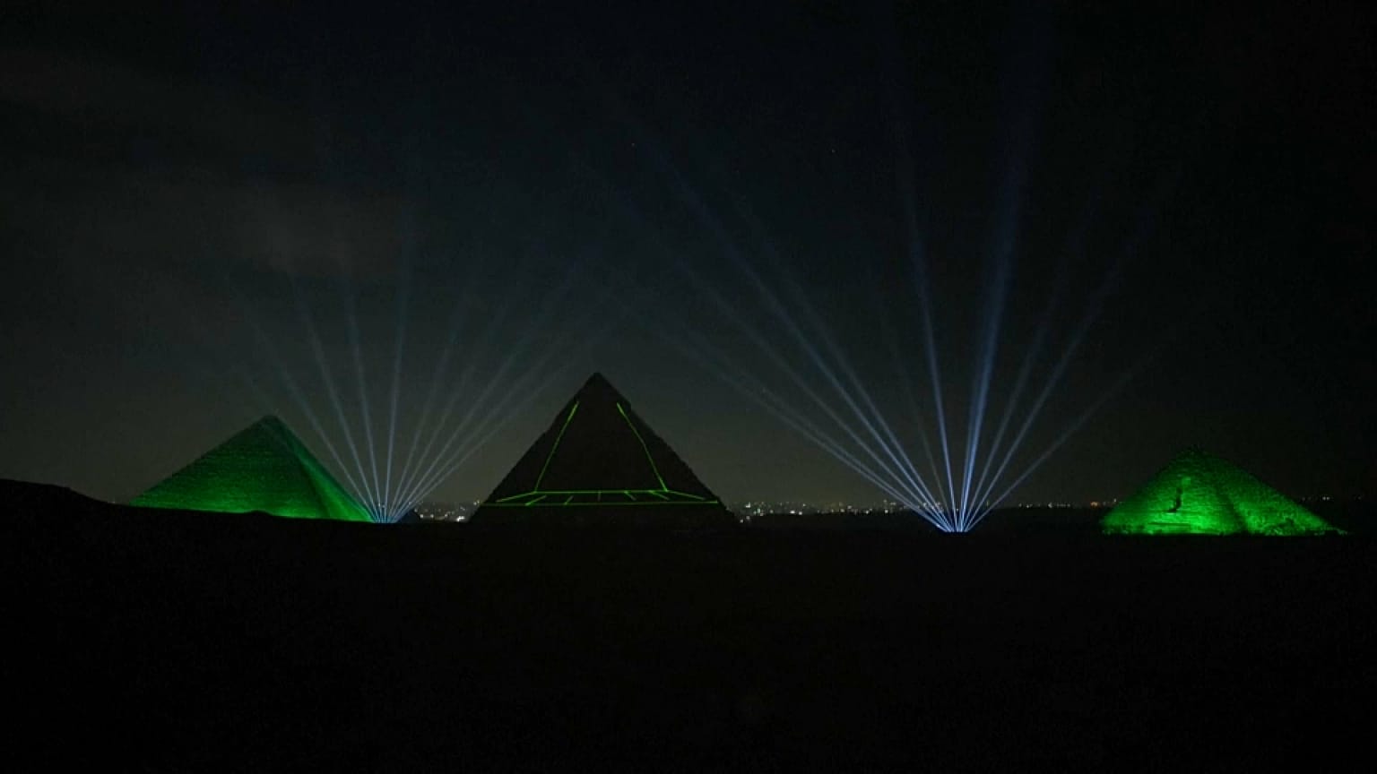 The illuminated pyramids light up the night sky 