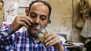 محمد المصري، صانع عطور في متجره في أحد الأسواق في دمشق القديمة، سوريا.