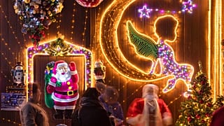 Menschen stehen vor dem weihnachtlich geschmückten Haus 