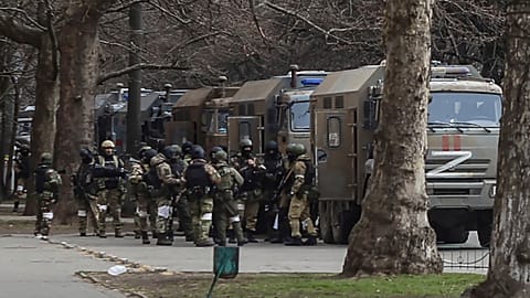 Russian army soldiers stand next to their trucks during a rally against Russian occupation in Svobody (Freedom) Square in Kherson, Ukraine, on March 7, 2022.