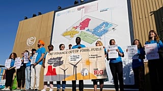 A group of demonstrators participate in an event protesting the use of fossil fuels at COP27.