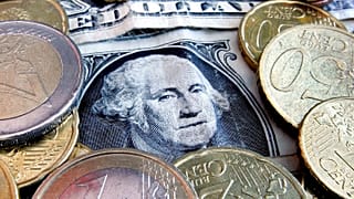 Euro coins and dollar bills are seen in Frankfurt, central Germany.