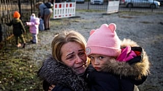 Svetlana Titova, 52, hugs her granddaughter as they arrive from the Russian-held town of Berdyansk, November 7, 2022.