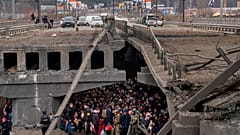 Des Ukrainiens se massent sous un pont détruit alors qu'ils tentent Irpin, en Ukraine, samedi 5 mars 2022.