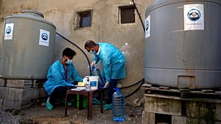 UNICEF'e bağlı sağlık çalışanları kolera salgınına karşı temizleme amaçlı klorlu su hazırlıyor