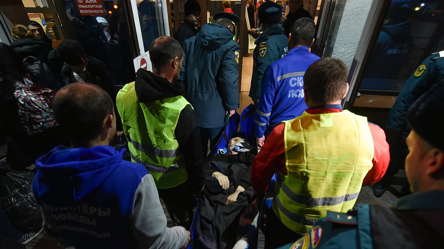 Volunteers and paramedics carry an elderly evacuee from Kherson into a hall on Nov. 10th 2022