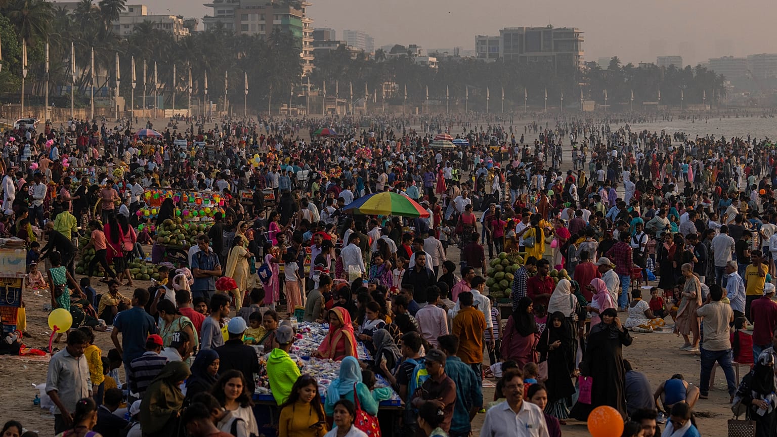 La gente se agolpa en la playa de Juhu, en la costa del Mar Arábigo, en Bombay, India, el domingo 13 de noviembre de 2022.