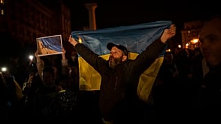 مواطن أوكراني يرفع علم بلاده محتفلاً بتحرير خيرسون 