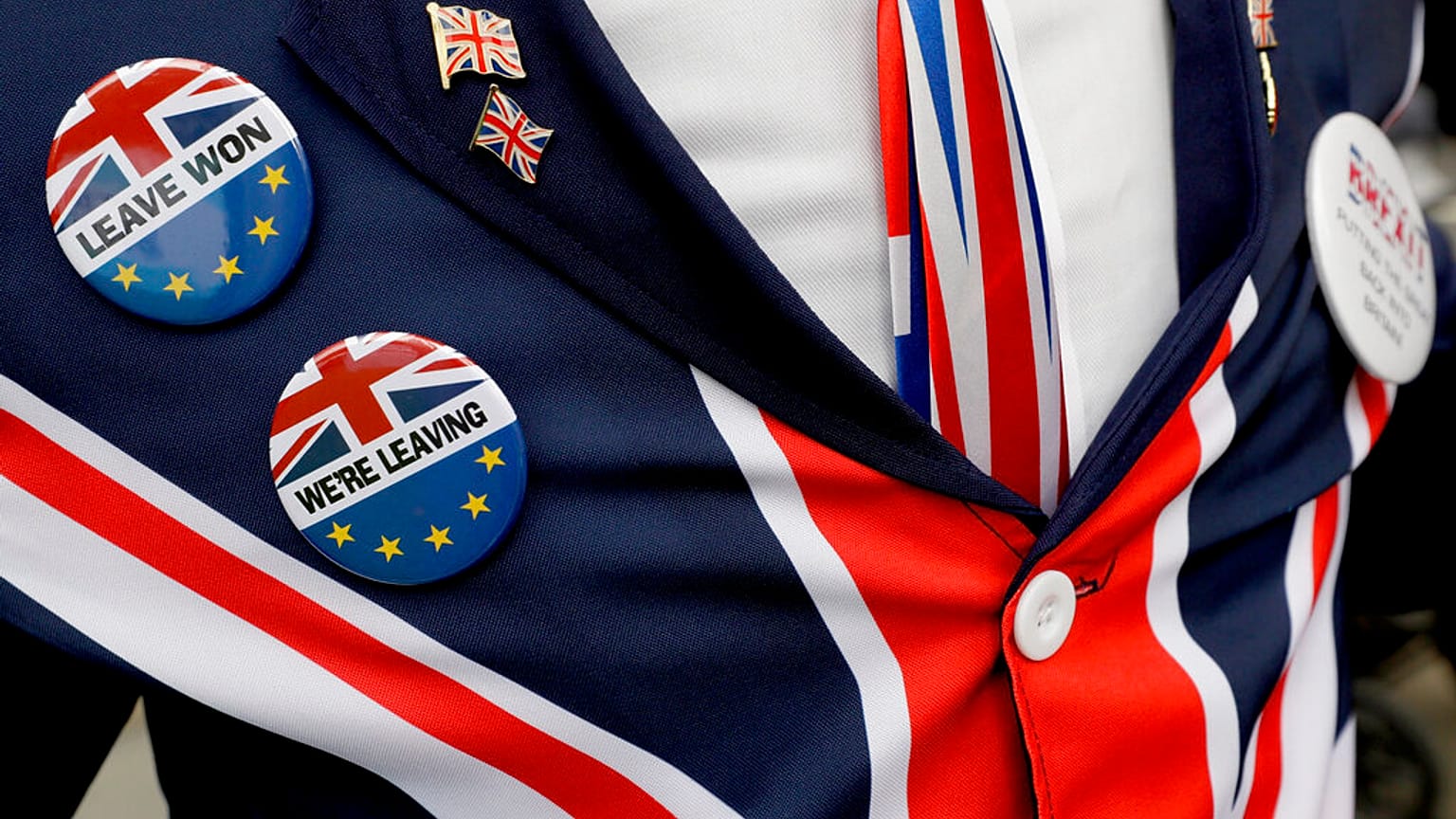 Pro-Brexit supporter wears badges as he demonstrates outside Parliament in London, Oct. 28, 2019. 
