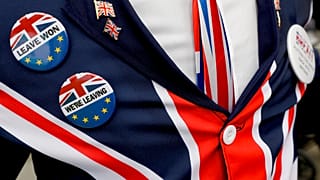 Brexit supporter wears badges as he demonstrates outside Parliament in London, Oct. 28, 2019.
