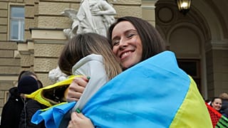 População na praça central de Kherson, Ucrânia, celebra libertação da Rússia com bandeiras ucranianas