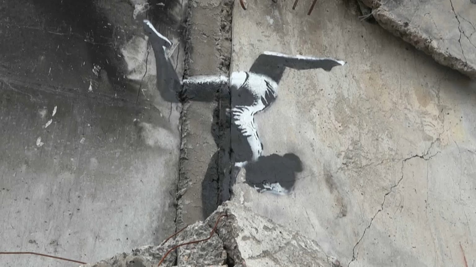 Une gymnaste en équilibre sur des gravats, l'œuvre de Banksy à Borodianka, en Ukraine.
