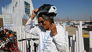 Dorothee Hildebrandt, 72, removes her bike helmet after arriving to the UN climate summit.